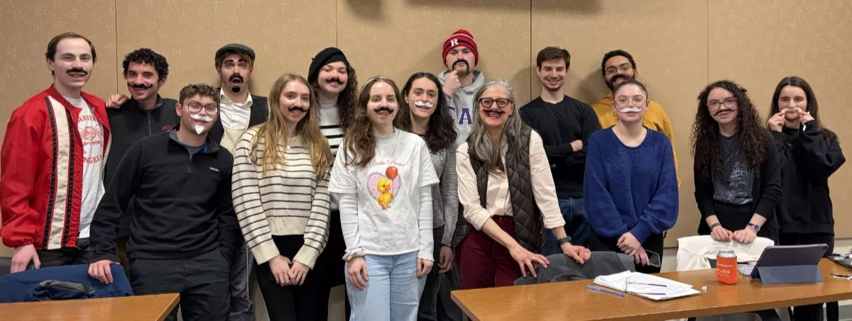 Group photo from Purim party; all attendees are wearing fake mustaches as their costumes